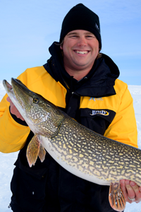 image of ice fisherman holding large Pike